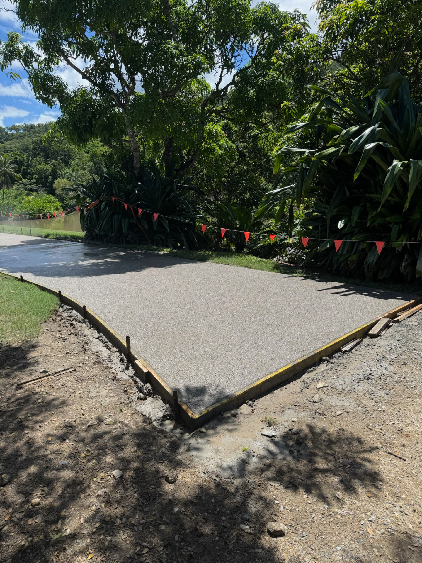 Exposed aggregate concrete apron beside a driveway